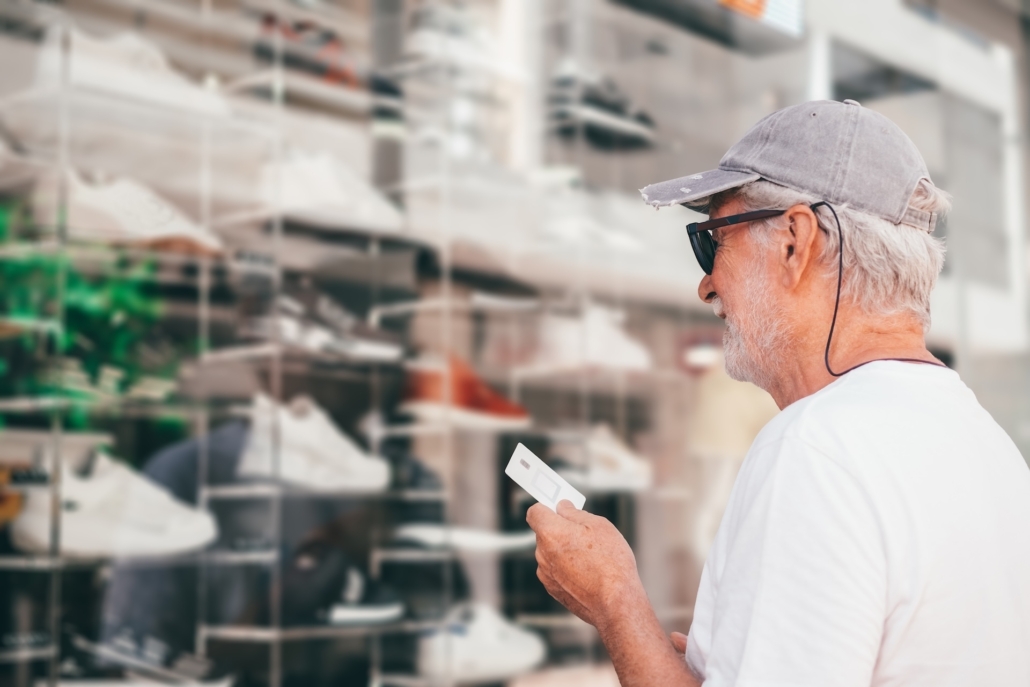 Happy senior man looking the shop windows of a store holding credit card for payment ready to profit on summer sales and discounts Schaufenster putzen, Ladenlokale und Gewerbeflächen reinigen 1